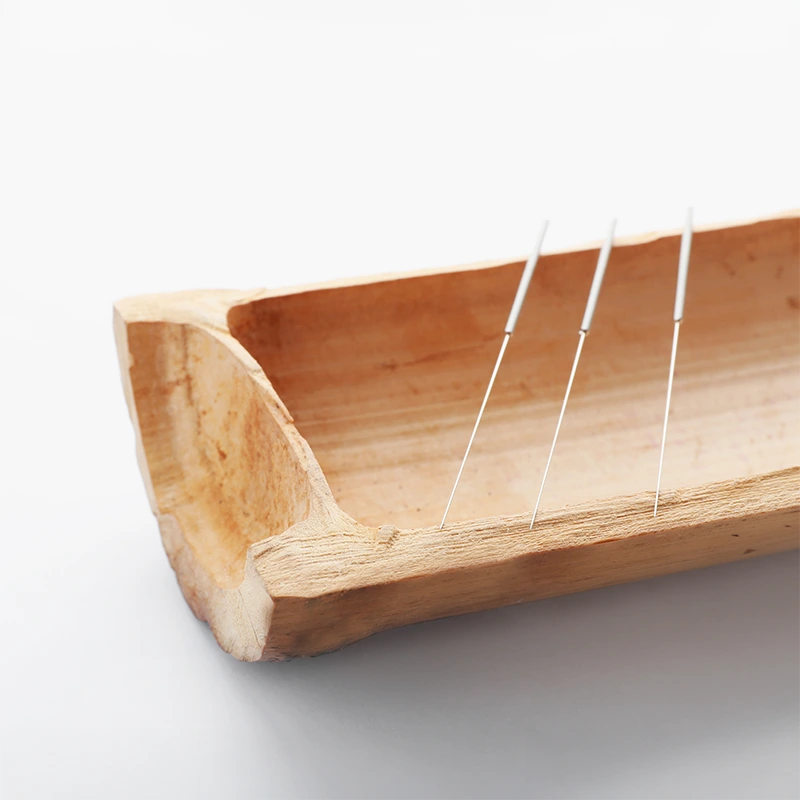 image of acupuncture needles on a piece of wood